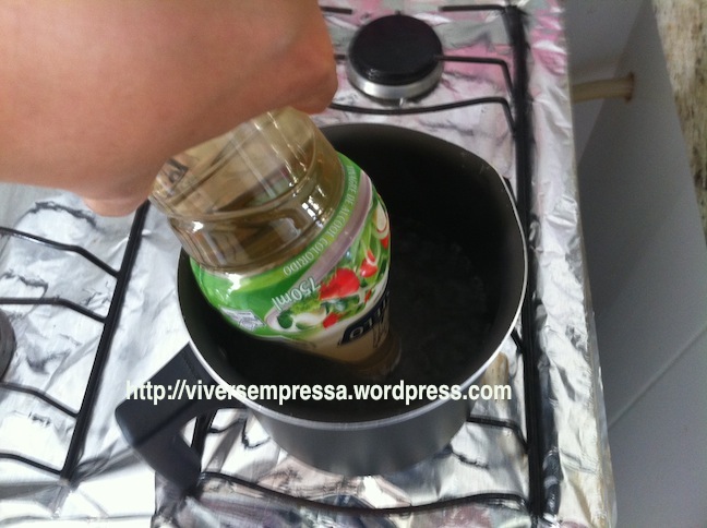 Ferva água numa panela e coloque a garrafa do vinagre (com a tampa lacrada) de ponta cabeça e encoste apenas a tampa na água fervente por 10 segundos.