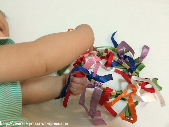 Fiz esse brinquedo usando bastidor de madeira e amarrando várias fitas coloridas.